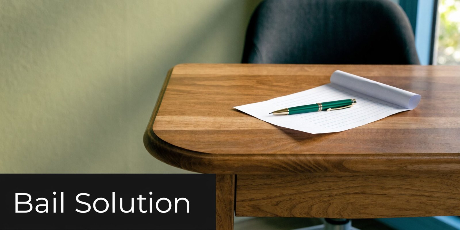 A wooden desk featuring a green pen resting on a lined piece of paper with copy space.