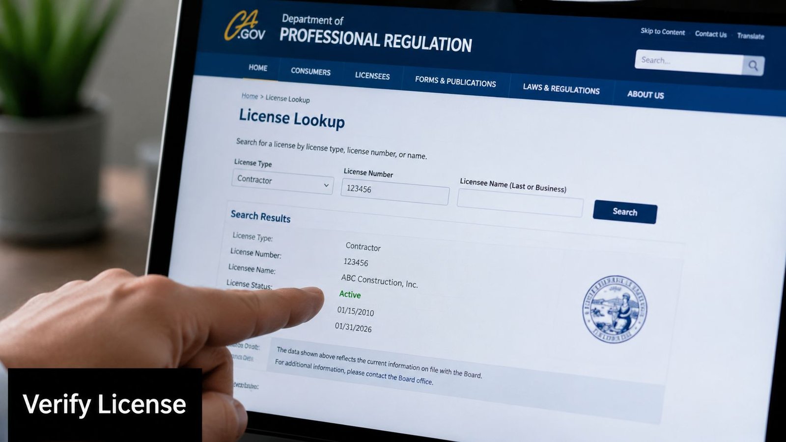 A person pointing at a screen showing active contractor license verification results on a government website.