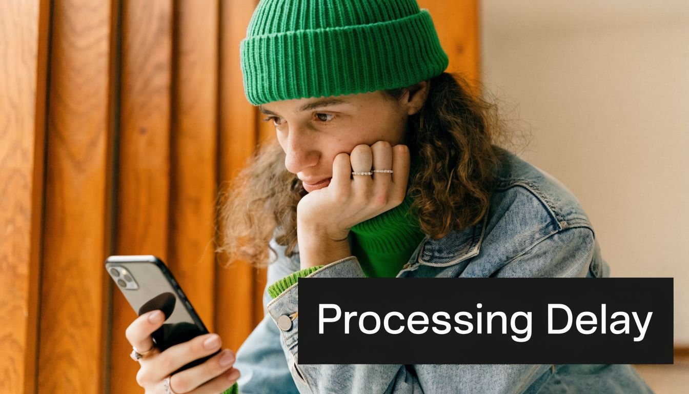 A person wearing a green beanie and denim jacket looking at their smartphone with a focused expression.