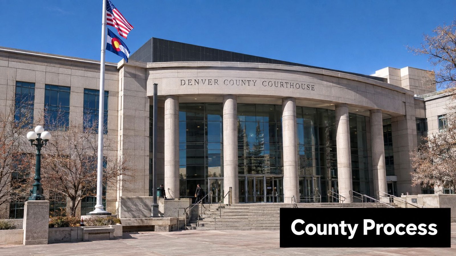 The exterior facade of the Denver County Courthouse building under a bright blue clear sky.